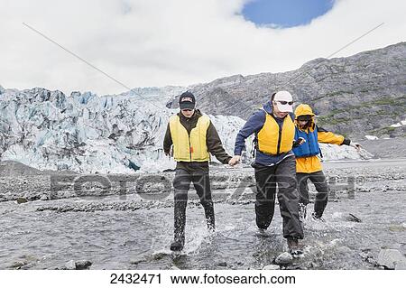 Mother with two teenage sons wearing life jackets, crossing a stream in front of Shoup glacier and Chugach mountains, Shoup Bay State Marine Park, Prince William Sound; Valdez, Alaska, United States of America View Large Photo Image Stock Image - Mother with two teenage sons wearing life jackets, crossing a stream in front of Shoup glacier and Chugach mountains, Shoup Bay State Marine Park, Prince William Sound; Valdez, Alaska, United States of America. Fotosearch