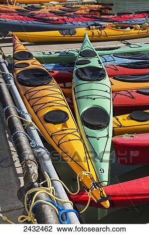Stock Image - Multi-coloured kayaks together at boat dock, Prince William Sound; Valdez, Alaska, United States of America. Fotosearch