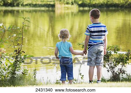 Older brother showing is sister the lake and holding her hand for safety; Edmonton, Alberta, Canada View Large Photo Image Stock Image - Older brother showing is sister the lake and holding her hand for safety; Edmonton, Alberta, Canada. Fotosearch