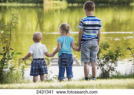 Older brother with siblings looking at lake and holding hands for safety; Edmonton, Alberta, Canada View Large Photo Image Stock Image - Older brother with siblings looking at lake and holding hands for safety; Edmonton, Alberta, Canada. Fotosearch