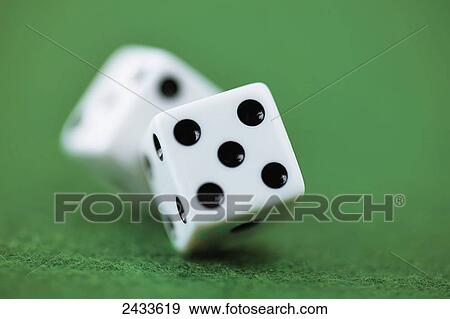 Stock Photo - Pair of white dice rolling on green felt. Fotosearch