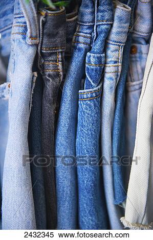 Stock Photography - Pairs of denim jeans hanging on a clothes rack; London, England. Fotosearch