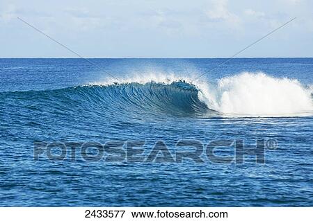 Stock Photo - Perfect empty waves break in tropical ocean in the South Pacific; Tahiti, French Polynesia. Fotosearch