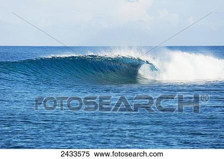 Stock Photography - Perfect empty waves break in tropical ocean in the South Pacific; Tahiti, French Polynesia. Fotosearch