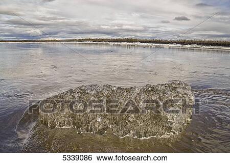 Piece of ice grounded in the Porcupine River during the spring break up of the river; Old Crow, Yukon, Canada View Large Photo Image Stock Photograph - Piece of ice grounded in the Porcupine River during the spring break up of the river; Old Crow, Yukon, Canada. Fotosearch