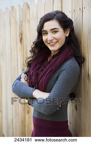 Portait of a teenaged girl leaning against a wooden fence; San Francisco, California, United States of America View Large Photo Image Stock Image - Portait of a teenaged girl leaning against a wooden fence; San Francisco, California, United States of America. Fotosearch