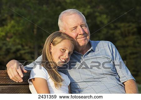 Portrait of a grandfather and granddaughter sitting on a park bench; Edmonton, Alberta, Canada View Large Photo Image Stock Photo - Portrait of a grandfather and granddaughter sitting on a park bench; Edmonton, Alberta, Canada. Fotosearch