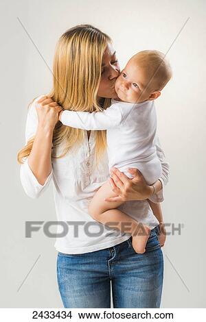 Portrait of a mother holding and kissing her baby daughter; Tarifa, Cadiz, Andalusia, Spain View Large Photo Image Picture - Portrait of a mother holding and kissing her baby daughter; Tarifa, Cadiz, Andalusia, Spain. Fotosearch