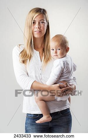 Stock Image - Portrait of a mother holding her baby daughter; Tarifa, Cadiz, Andalusia, Spain. Fotosearch