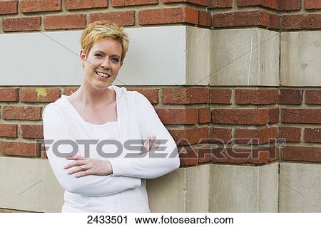 Portrait of a woman standing against a brick wall; Edmonton, Alberta, Canada View Large Photo Image Stock Image - Portrait of a woman standing against a brick wall; Edmonton, Alberta, Canada. Fotosearch