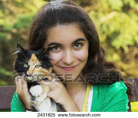 Stock Photography - Portrait of a young girl holding a cat outdoors; Sherwood Park, Alberta, Canada. Fotosearch