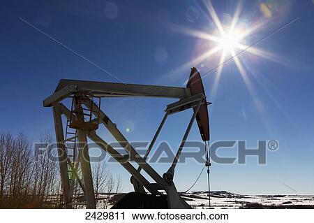 Pumpjack and snow covered hills with sun burst and blue sky; Longview, Alberta, Canada View Large Photo Image Stock Image - Pumpjack and snow covered hills with sun burst and blue sky; Longview, Alberta, Canada. Fotosearch