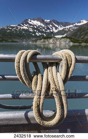 Rope hanging on the rails of a boat with mountains in background, Shoup Bay State Marine Park, Prince William Sound; Valdez, Alaska, United States of America View Large Photo Image Stock Photo - Rope hanging on the rails of a boat with mountains in background, Shoup Bay State Marine Park, Prince William Sound; Valdez, Alaska, United States of America. Fotosearch