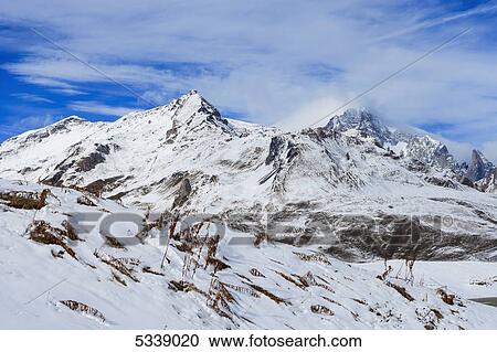 Stock Image - Rugged snow covered mountains, viewed from Little St Bernard Pass; Italy. Fotosearch