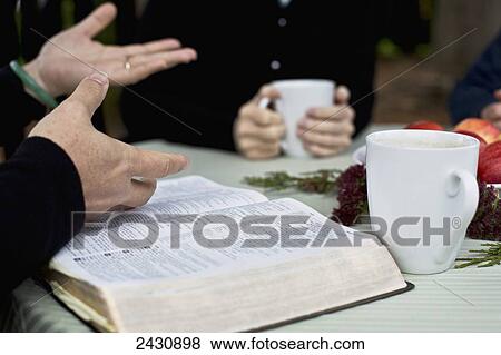 Stock Photo - Sharing a cup of coffee and reading the Bible; Abbotsford, British Columbia, Canada. Fotosearch