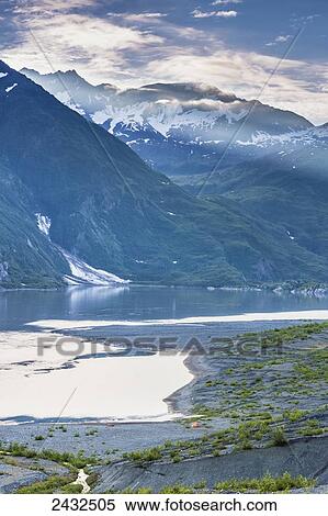 Stock Photography - Shoup Bay shoreline with tent and kayak on beach in front of the Chugach mountains, Shoup Bay State Marine Park, Prince William Sound; Valdez, Alaska, United States of America. Fotosearch