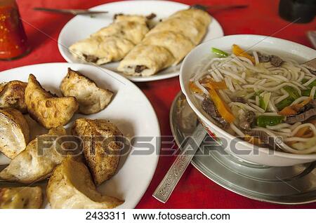 Stock Image - Special Tibetan momos, spring rolls and noodles in a Tibetan restaurant; Pokhara, Nepal. Fotosearch