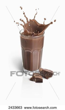 Stock Image - Splashing chocolate milk from a glass with pieces of chocolate. Fotosearch