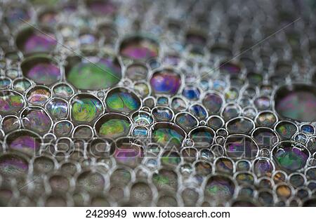 Stock Photo - Surf leaves colourful bubbles on the beach; Cannon Beach, Oregon, United States of America. Fotosearch