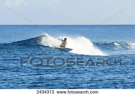 Stock Image - Surfer riding perfect waves in the South Pacific; Tahiti, French Polynesia. Fotosearch