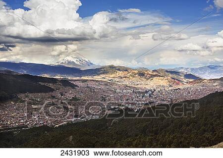 Stock Image - The city of La Paz with Illimani rising in the distance, the highest peak in Bolivia; La Paz, Bolivia. Fotosearch