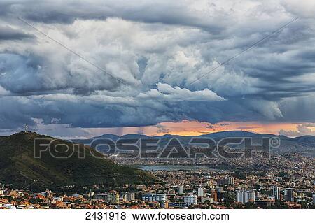 The skies turn stormy over the skies of Cochabamba, with El Cristo seen on the mountain in the middle of the city; Bolivia View Large Photo Image Stock Photo - The skies turn stormy over the skies of Cochabamba, with El Cristo seen on the mountain in the middle of the city; Bolivia. Fotosearch