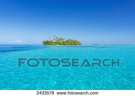Stock Photo - Tropical sunny island with palm trees and blue ocean; Raiatea, French Polynesia. Fotosearch