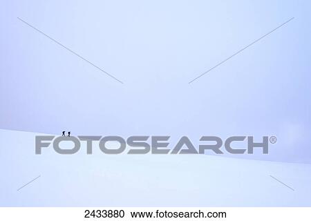 Stock Image - Two people walking along ridge in snow covered, winter conditions on Beinn an Dothaidh, near Bridge of Orchy; Argyll and Bute, Scotland. Fotosearch