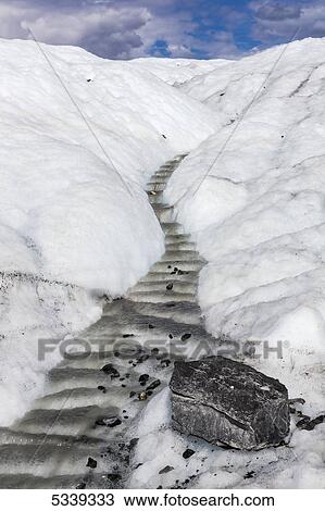 Stock Image - View of a river flowing through an ice channel from the Matanuska Glacier; Alaska, United States of America. Fotosearch