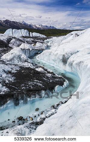 Stock Photograph - View of a river flowing through an ice channel from the Matanuska Glacier; Alaska, United States of America. Fotosearch