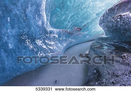 Stock Image - View of an ice tunnel and river flowing inside of the Matunuska Glacier; Alaska, United States of America. Fotosearch