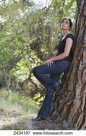 Woman leaning against a tree; San Francisco, California, United States of America View Large Photo Image Stock Photo - Woman leaning against a tree; San Francisco, California, United States of America. Fotosearch