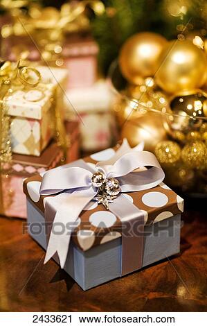 Stock Image - Wrapped Christmas gifts with decorated tree; Montreal, Quebec, Canada. Fotosearch