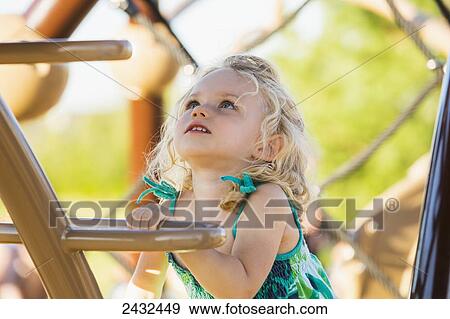 Stock Photo - Young girl climbing a ladder in a playground; Spruce Grove, Alberta, Canada. Fotosearch
