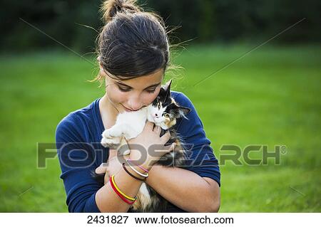 Young girl holding a cat outdoors; Sherwood Park, Alberta, Canada View Large Photo Image Stock Photo - Young girl holding a cat outdoors; Sherwood Park, Alberta, Canada. Fotosearch