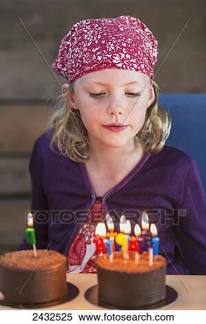 Young girl wearing red bandana on her head and blowing out the candles of a birthday cake; Anchorage, Alaska, United States of America View Large Photo Image Stock Photography - Young girl wearing red bandana on her head and blowing out the candles of a birthday cake; Anchorage, Alaska, United States of America. Fotosearch