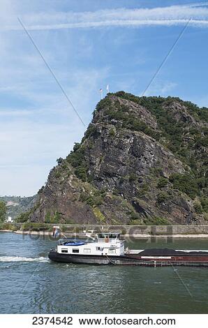 A barge sails down Rhine river by Loreley rock; Germany View Large Photo Image Stock Image - A barge sails down Rhine river by Loreley rock; Germany. Fotosearch
