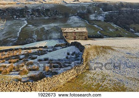 Stock Image - A Barn And Stone Walls With Snow On The Hills; Yorkshire Dales, England. Fotosearch