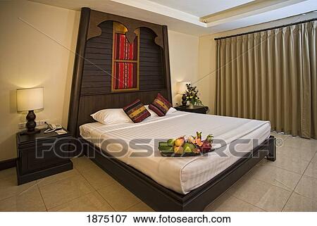 Stock Photo - A Bed In A Hotel Room With A Fruit Tray Displayed On It. Fotosearch