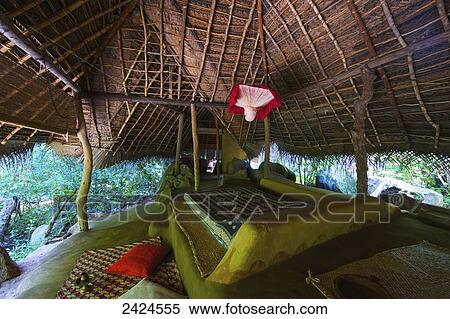 Stock Photography - A bed in a shelter with slanted roof; Ulpotha, Embogama, Sri Lanka. Fotosearch