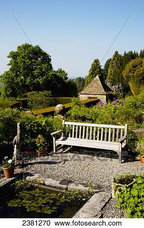 Stock Image - A bench in the gardens, Milton Lodge Gardens; Wells, Somerset, England. Fotosearch