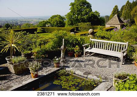Stock Image - A bench in the gardens, Milton Lodge Gardens; Wells, Somerset, England. Fotosearch