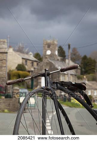 Stock Image - A Bicycle In The Foreground With Houses In The Background; Muker Village Yorkshire England. Fotosearch