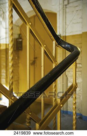 Stock Photo - A black handrail and yellow painted metal balusters inside a building; Hamburg, Germany. Fotosearch