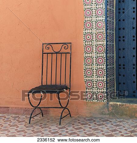 A Black Metal Chair Sits Against A Colourful Wall; Talouste, Souss-Massa-Drass, Morocco View Large Photo Image Stock Image - A Black Metal Chair Sits Against A Colourful Wall; Talouste, Souss-Massa-Drass, Morocco. Fotosearch