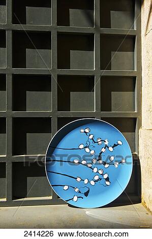 A blue decorative plate leaning against a wall with a square block facade; Barcelona, Spain View Large Photo Image Stock Photograph - A blue decorative plate leaning against a wall with a square block facade; Barcelona, Spain. Fotosearch