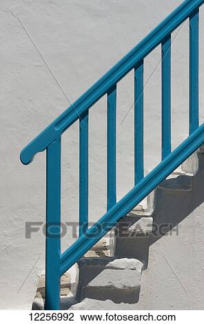 Stock Image - A blue railing on white painted stone stairs; Mykonos Town, Mykonos, Cyclades, Greek Islands, Greece. Fotosearch