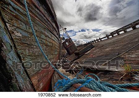 Stock Image - A Blue Rope Tied To An Old Weathered Wooden Boat On A Wooden Dock; Salem Isle Of Mull Scotland. Fotosearch