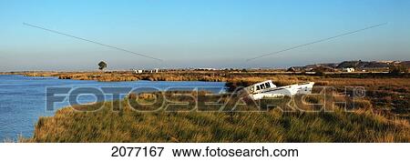 Stock Photo - A Boat Abandoned On The Shore By The River; Jerez De La Frontera Andalusia Spain. Fotosearch