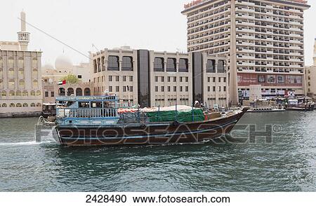 Stock Image - A boat carrying cargo; Dubai, United Arab Emirates. Fotosearch